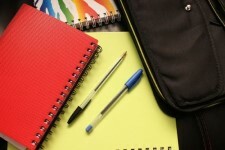 Photo of three spiral bound notebooks in various colours with two pens